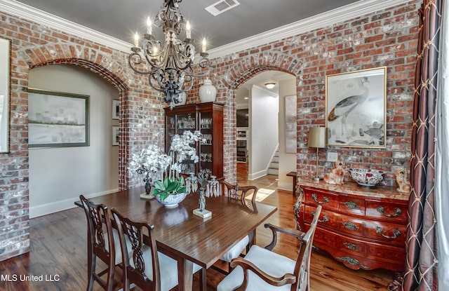 521 Heyward Ln, Madison, MS 39110 - dining space with arched walkways, baseboards, a chandelier, ornamental molding, and brick wall