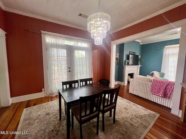 701 Court St, Cleveland, MS 38732 - dining room featuring an inviting chandelier, ornamental molding, wood finished floors, a fireplace, and french doors