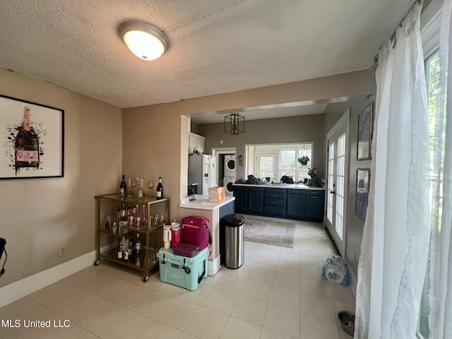 701 Court St, Cleveland, MS 38732 - interior space featuring plenty of natural light, stacked washer and clothes dryer, refrigerator with ice dispenser, and a textured ceiling