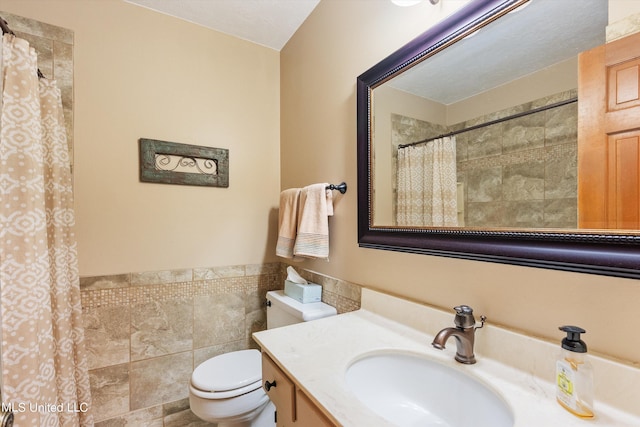 bathroom with a shower with curtain, vanity, toilet, and tile walls