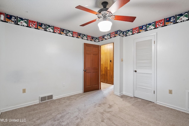 unfurnished bedroom featuring light colored carpet, ceiling fan, and a closet