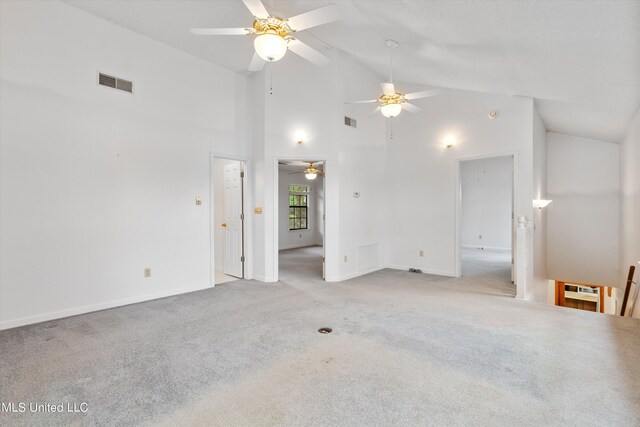 unfurnished room with high vaulted ceiling and light carpet