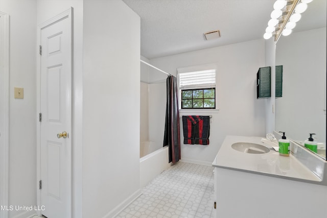 bathroom with vanity, shower / bath combination with curtain, and a textured ceiling