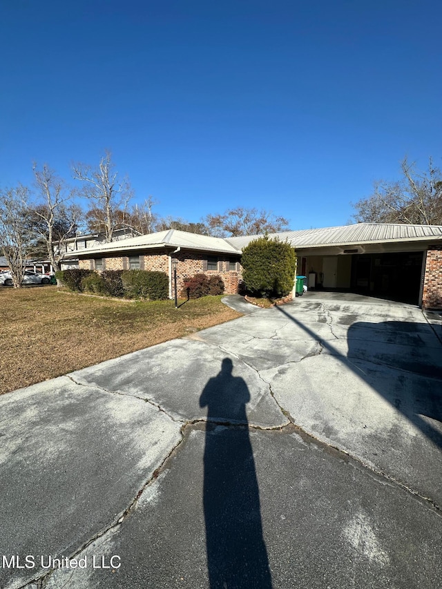 view of front of home with concrete driveway and a front lawn