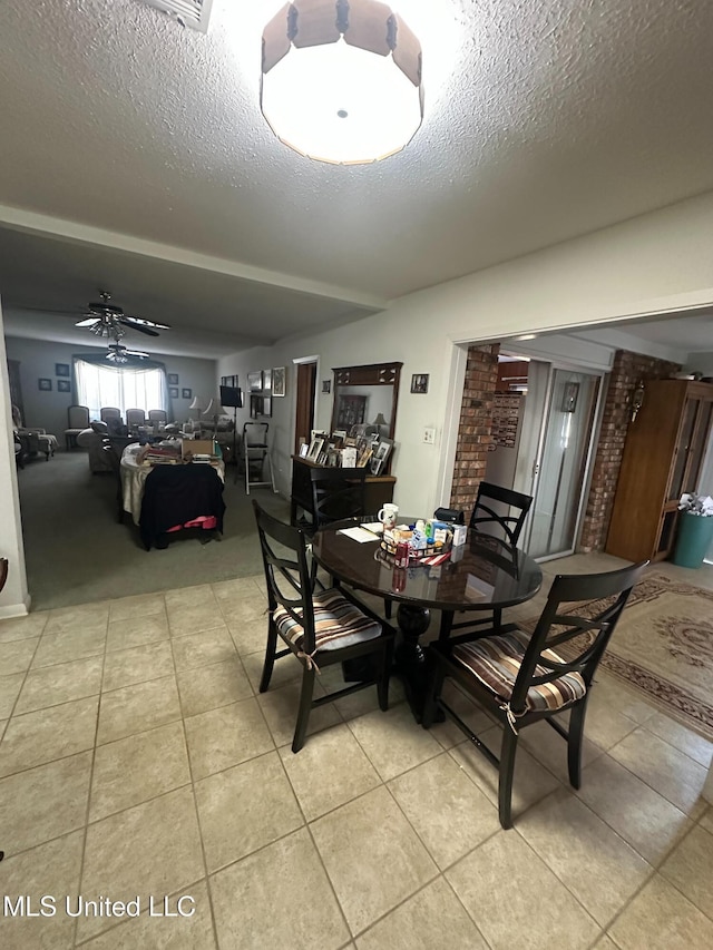 tiled dining area featuring a textured ceiling and ceiling fan