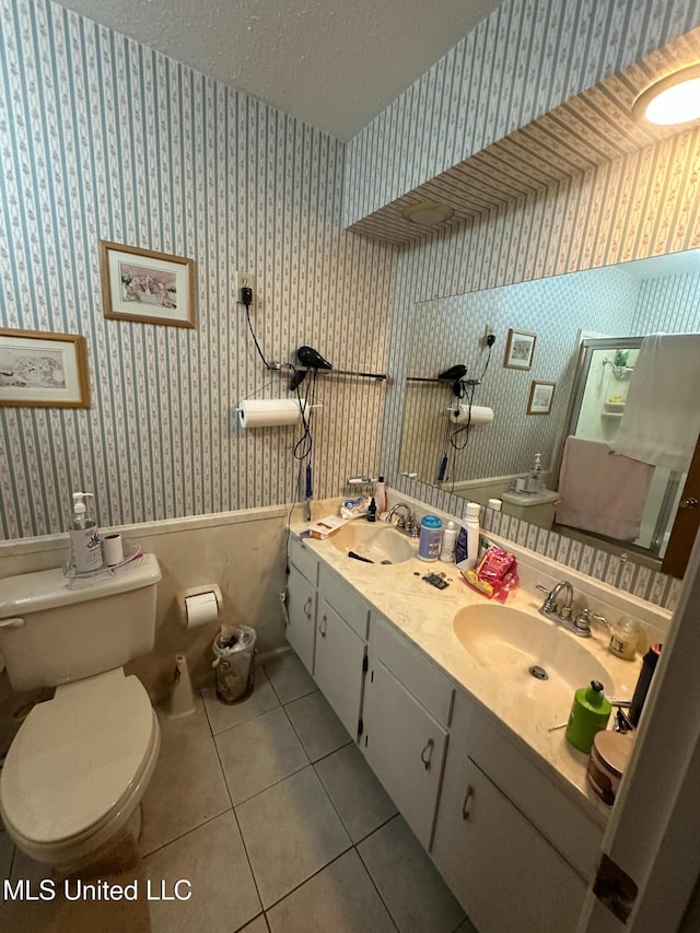 full bathroom featuring a sink, toilet, and wallpapered walls