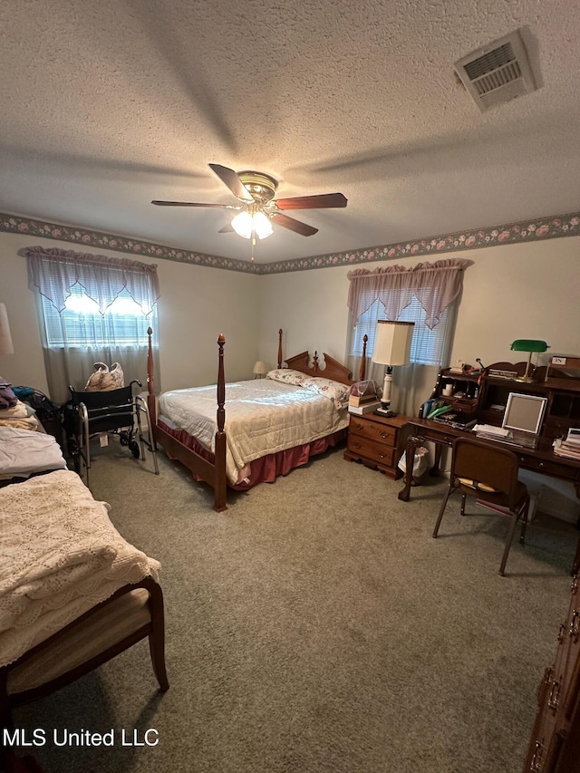 carpeted bedroom with a ceiling fan, visible vents, and a textured ceiling