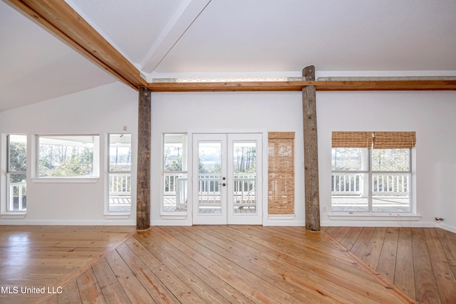 interior space with vaulted ceiling with beams, light hardwood / wood-style floors, and french doors