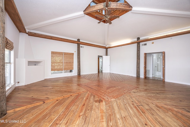 spare room featuring ceiling fan, a barn door, beam ceiling, and high vaulted ceiling