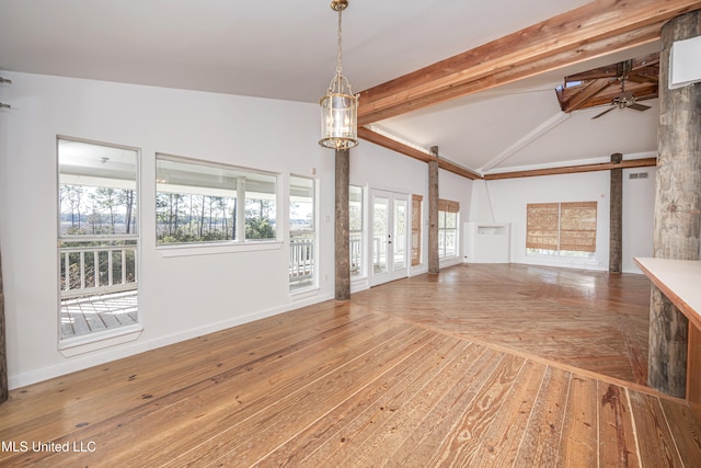 unfurnished living room featuring french doors, ceiling fan, lofted ceiling with beams, a barn door, and hardwood / wood-style flooring