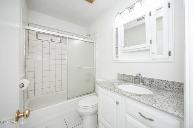 full bathroom with vanity, a textured ceiling, shower / bath combination with glass door, tile patterned flooring, and toilet