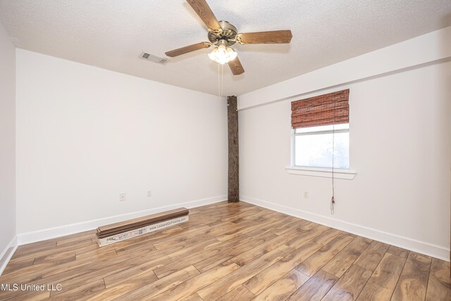 unfurnished room featuring ceiling fan, light wood-type flooring, and a textured ceiling