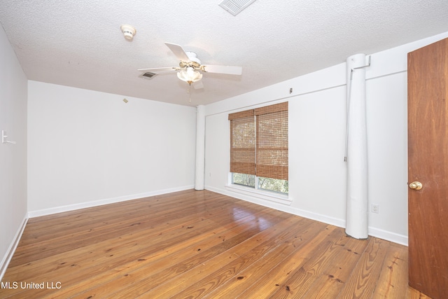 spare room with ceiling fan, light wood-type flooring, and a textured ceiling