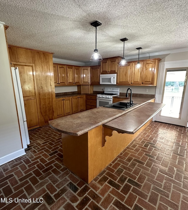 19728 Hwy 63, Moss Point, MS 39562 - kitchen featuring white appliances, a sink, brown cabinets, a kitchen bar, and brick flooring