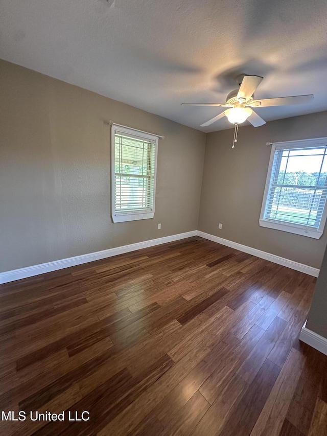 19728 Hwy 63, Moss Point, MS 39562 - unfurnished room with plenty of natural light, dark wood-style floors, ceiling fan, and baseboards
