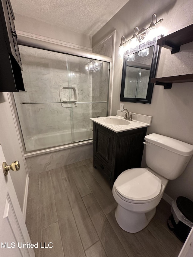 19728 Hwy 63, Moss Point, MS 39562 - full bath featuring enclosed tub / shower combo, a textured ceiling, wood finished floors, toilet, and vanity