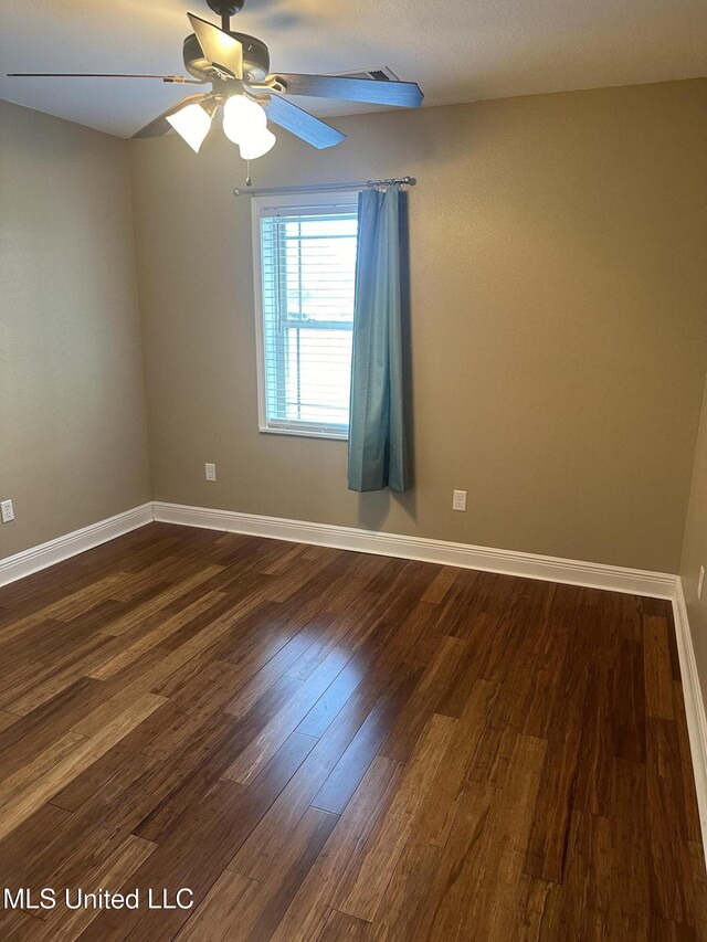 19728 Hwy 63, Moss Point, MS 39562 - spare room featuring ceiling fan, dark wood-type flooring, and baseboards