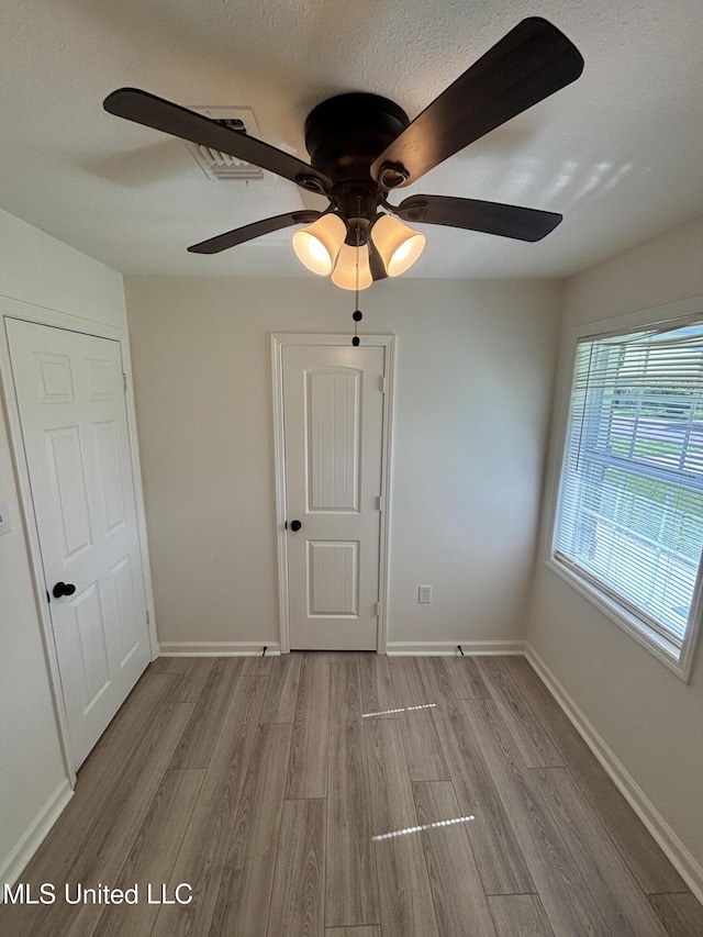 230 Greenbriar Cir, Holly Springs, MS 38635 - unfurnished bedroom with wood finished floors, baseboards, and ceiling fan