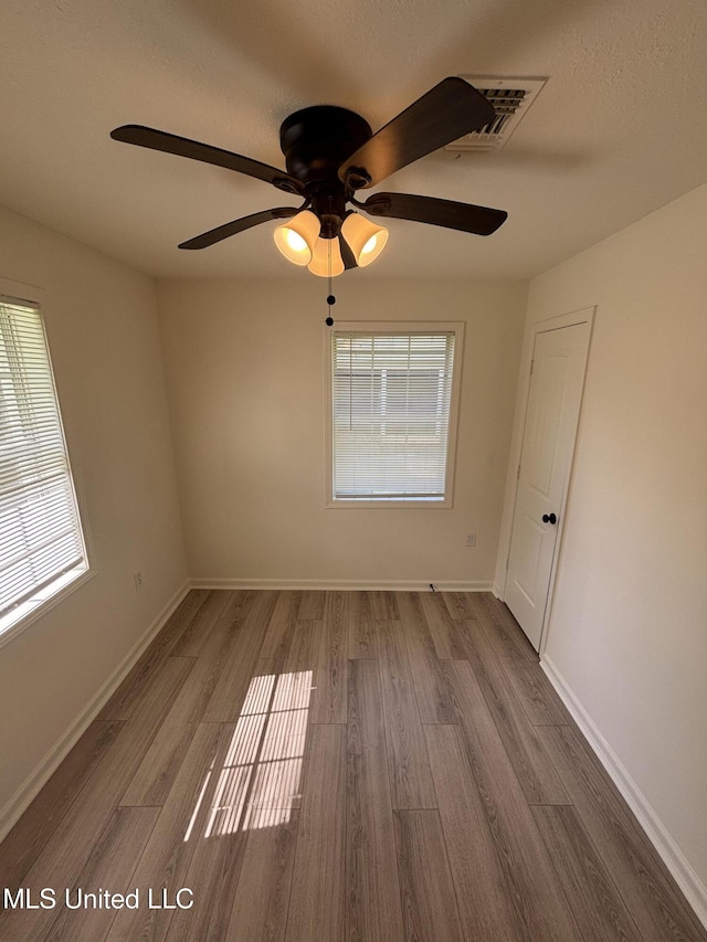 230 Greenbriar Cir, Holly Springs, MS 38635 - empty room featuring wood finished floors, healthy amount of natural light, a ceiling fan, and baseboards