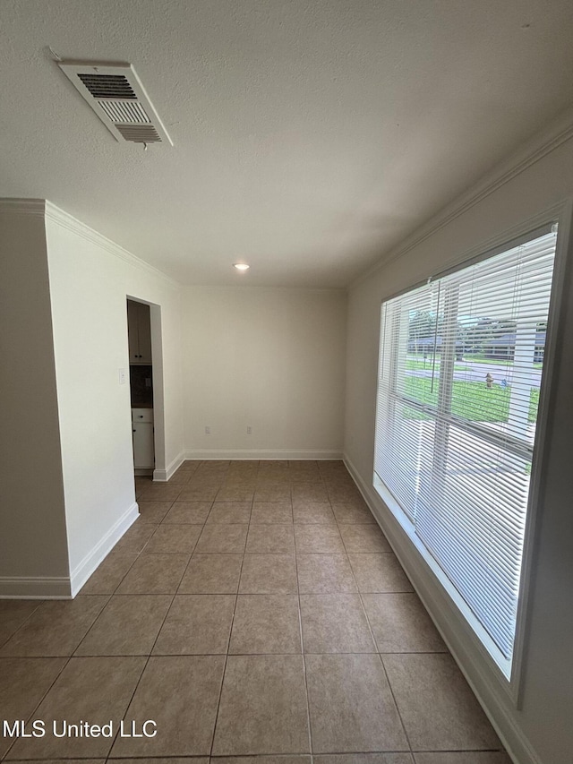 230 Greenbriar Cir, Holly Springs, MS 38635 - empty room with light tile patterned flooring, ornamental molding, baseboards, and a textured ceiling