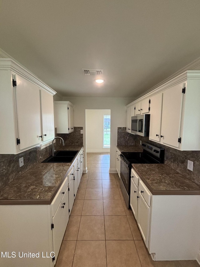 230 Greenbriar Cir, Holly Springs, MS 38635 - kitchen featuring appliances with stainless steel finishes, a sink, tasteful backsplash, white cabinetry, and dark countertops