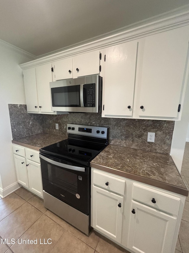 230 Greenbriar Cir, Holly Springs, MS 38635 - kitchen with stainless steel appliances, dark countertops, tasteful backsplash, ornamental molding, and white cabinetry