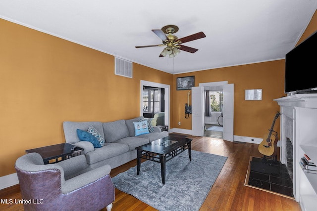 living room featuring a fireplace, ceiling fan, and dark wood-type flooring