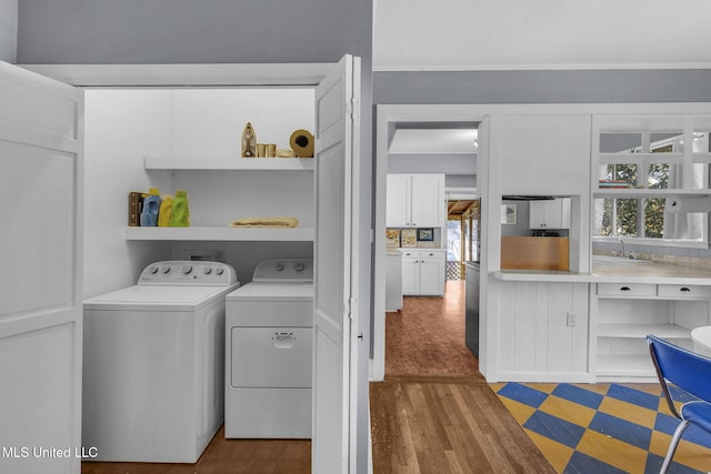 clothes washing area featuring hardwood / wood-style floors and washing machine and dryer