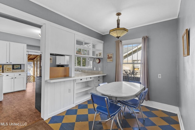 dining room featuring a healthy amount of sunlight, ornamental molding, and sink