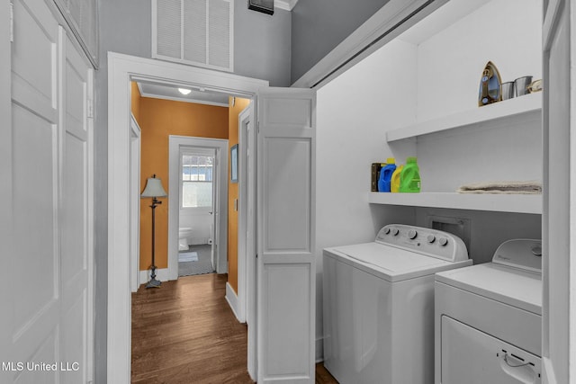 laundry room with crown molding, independent washer and dryer, and dark wood-type flooring