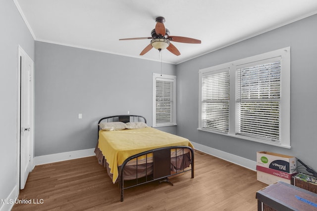 bedroom featuring hardwood / wood-style flooring, ceiling fan, and ornamental molding