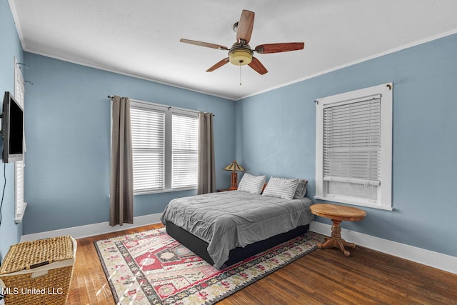 bedroom featuring dark hardwood / wood-style floors, ceiling fan, and crown molding