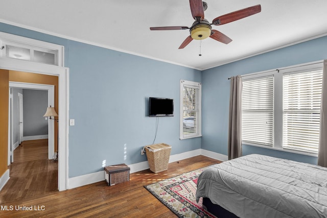 bedroom featuring ceiling fan, crown molding, and dark wood-type flooring