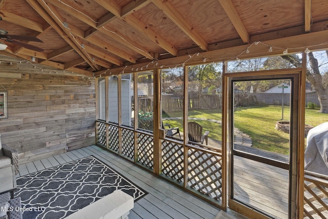 unfurnished sunroom featuring ceiling fan, beam ceiling, and wood ceiling