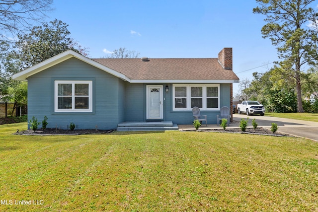 ranch-style home with concrete driveway, a front lawn, a chimney, and a shingled roof