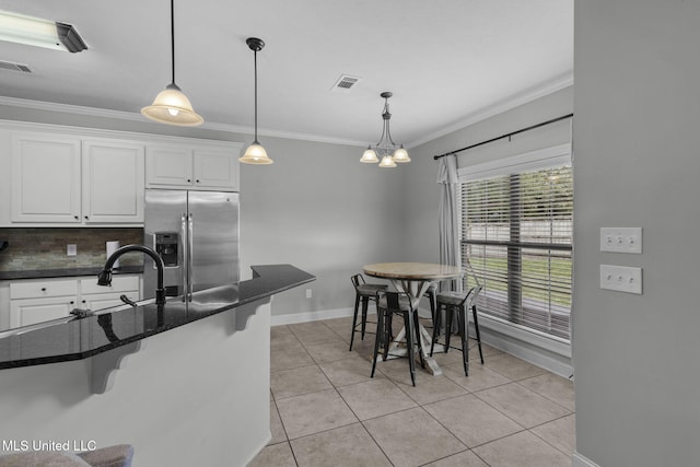 101 Marion Dr, Clinton, MS 39056 - kitchen featuring stainless steel fridge, ornamental molding, a kitchen bar, baseboards, and white cabinets