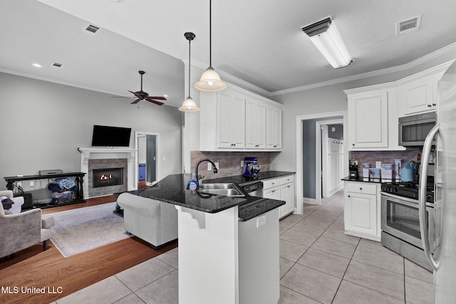 101 Marion Dr, Clinton, MS 39056 - kitchen featuring stainless steel appliances, open floor plan, a sink, a peninsula, and backsplash