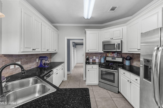 101 Marion Dr, Clinton, MS 39056 - kitchen featuring stainless steel appliances, a sink, dark countertops, white cabinetry, and light tile patterned floors