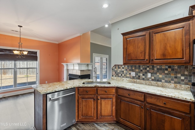 kitchen with a fireplace, tasteful backsplash, stainless steel dishwasher, sink, and dark hardwood / wood-style floors