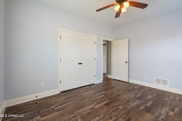 unfurnished bedroom with ceiling fan, dark hardwood / wood-style floors, and a closet