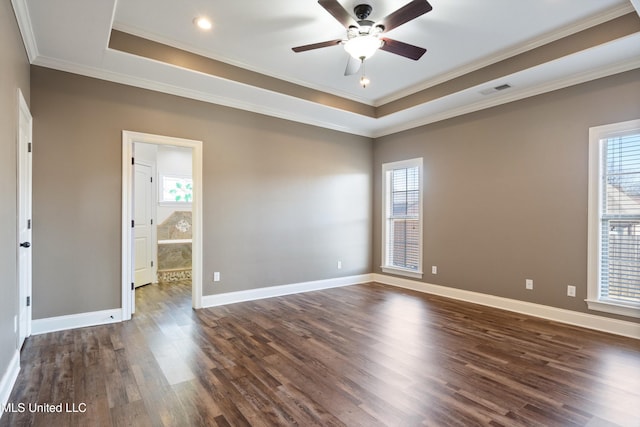 spare room featuring a tray ceiling, dark hardwood / wood-style flooring, and crown molding