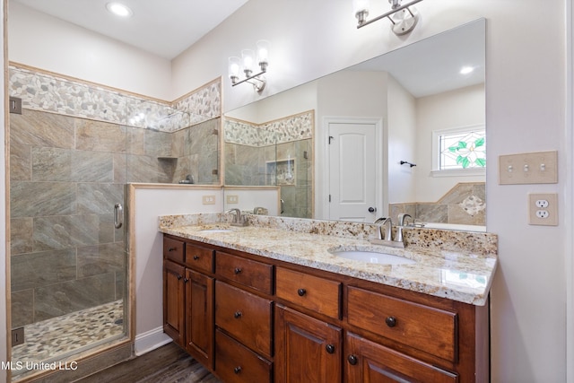 bathroom with hardwood / wood-style floors, walk in shower, and vanity