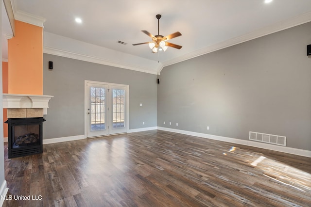 unfurnished living room featuring a tile fireplace, dark hardwood / wood-style flooring, and crown molding