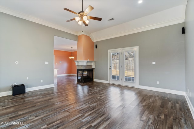 unfurnished living room with ceiling fan with notable chandelier, a multi sided fireplace, dark hardwood / wood-style flooring, and ornamental molding