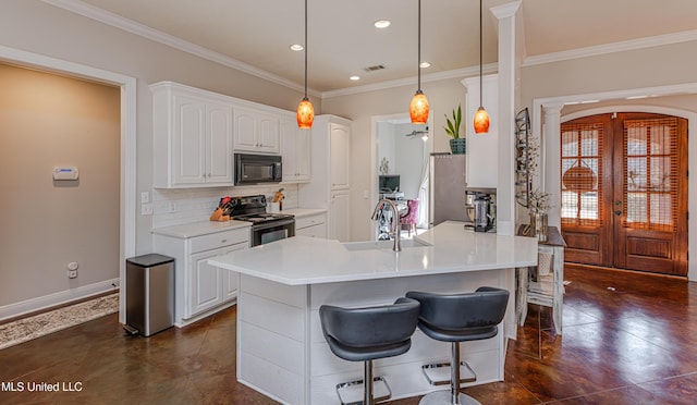 kitchen with tasteful backsplash, white cabinetry, sink, hanging light fixtures, and black appliances