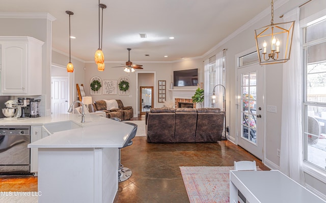 kitchen with sink, crown molding, dishwasher, white cabinets, and decorative light fixtures