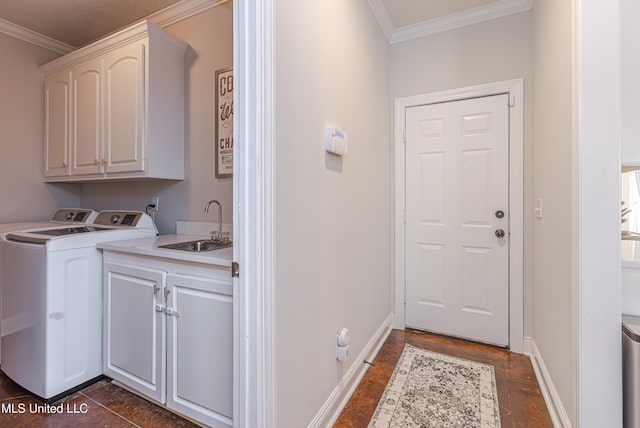 clothes washing area with sink, crown molding, washing machine and dryer, and cabinets