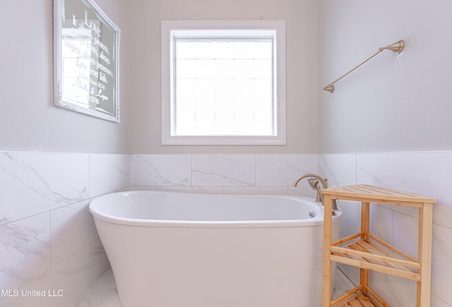 bathroom with tile walls and a tub