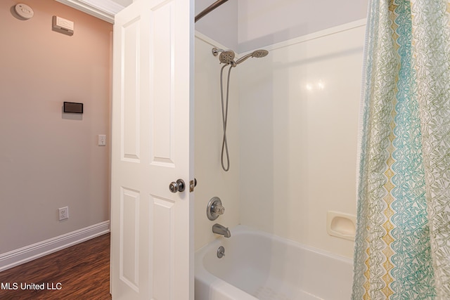 bathroom with hardwood / wood-style flooring and shower / tub combo with curtain