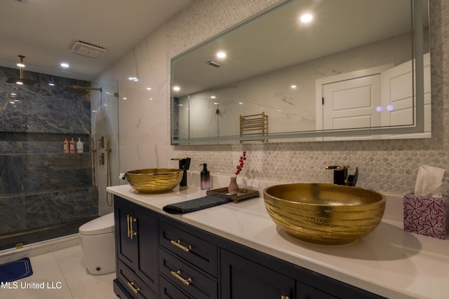 bathroom with a marble finish shower, decorative backsplash, tile walls, and vanity